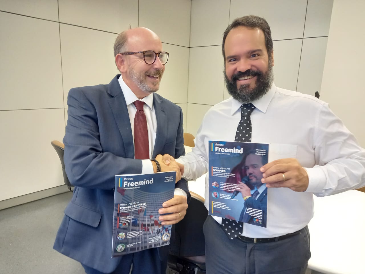 Paulo Martelli entregando duas edições da Revista Freemind ao Dr. Quirino Cordeiro Junior