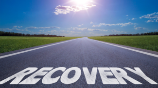 An image of a road path with the word 'Recovery' leading towards the sunrise.